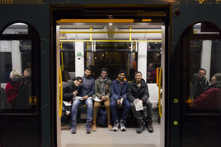 Menschen sitzen nebeneinander in einem Tram / Englisch:People sitting next to each other in a streetcar