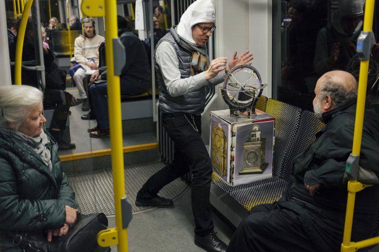 Mann zeigt anderen Menschen seine Box mit Erdkugel / Englisch:Man shows other people his box with globe