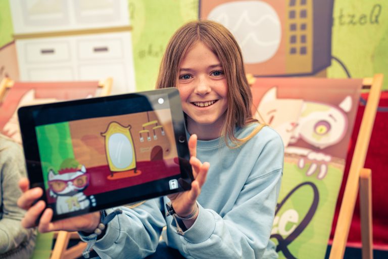 Ein Kind zeigt ein iPad vor der Kamera / Englisch:A child shows an iPad to the camera