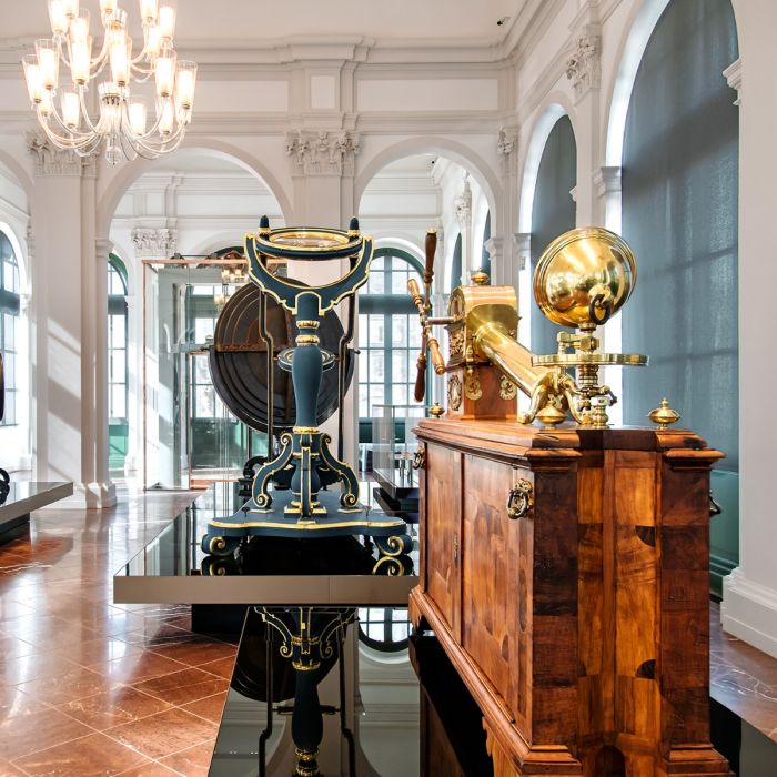 Telescope and lenses from the Mathematisch-Physikalischer Salon, illustrating historical scientific instruments. Logo